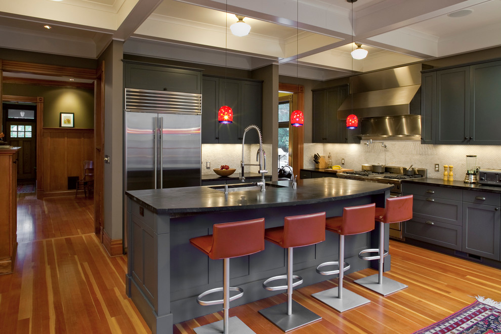 На фото: кухня в классическом стиле с фасадами в стиле шейкер, серыми фасадами, бежевым фартуком и техникой из нержавеющей стали