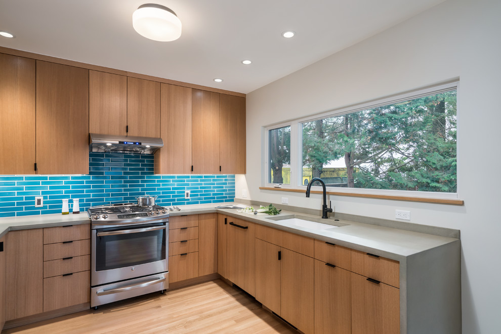 Example of a mid-sized trendy u-shaped light wood floor and beige floor eat-in kitchen design in Portland with flat-panel cabinets, medium tone wood cabinets, quartz countertops, blue backsplash, subway tile backsplash, stainless steel appliances and gray countertops