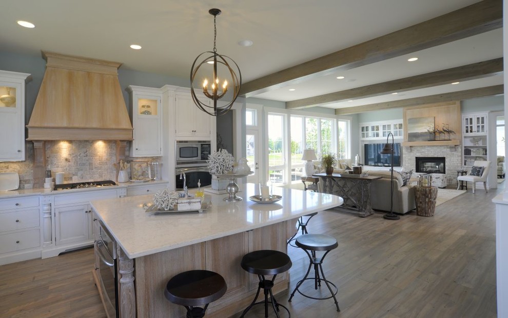 Eat-in kitchen - coastal l-shaped vinyl floor, gray floor and exposed beam eat-in kitchen idea in Columbus with an undermount sink, recessed-panel cabinets, white cabinets, multicolored backsplash, stone tile backsplash, stainless steel appliances, an island and white countertops