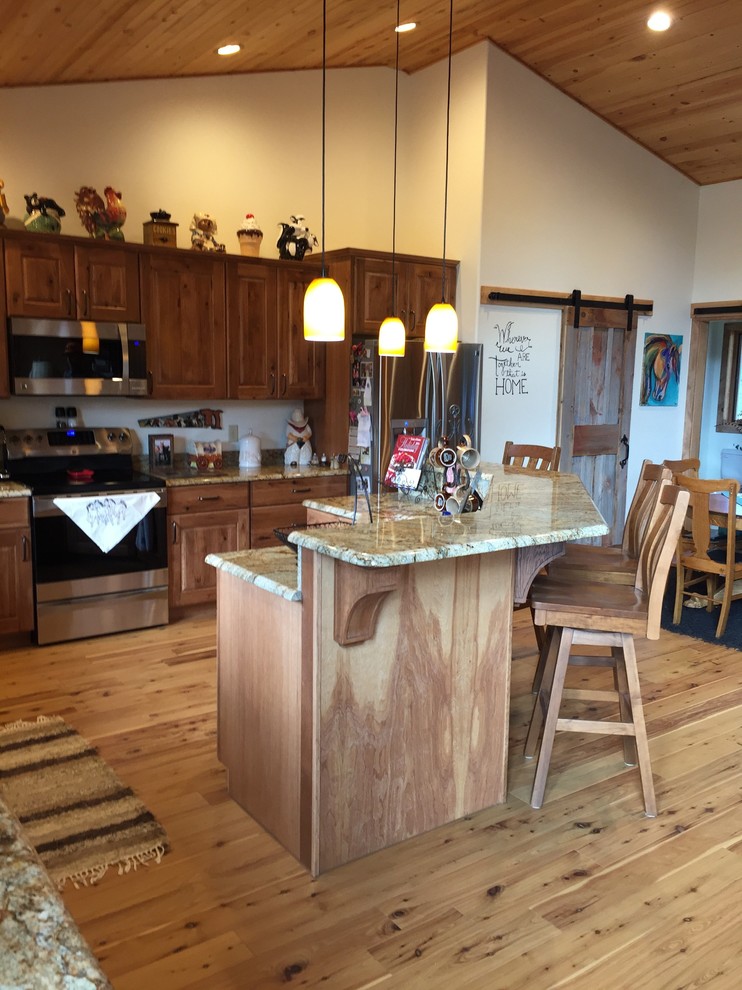 Example of a mid-sized mountain style l-shaped light wood floor open concept kitchen design in Other with an undermount sink, raised-panel cabinets, medium tone wood cabinets, granite countertops, stainless steel appliances and an island