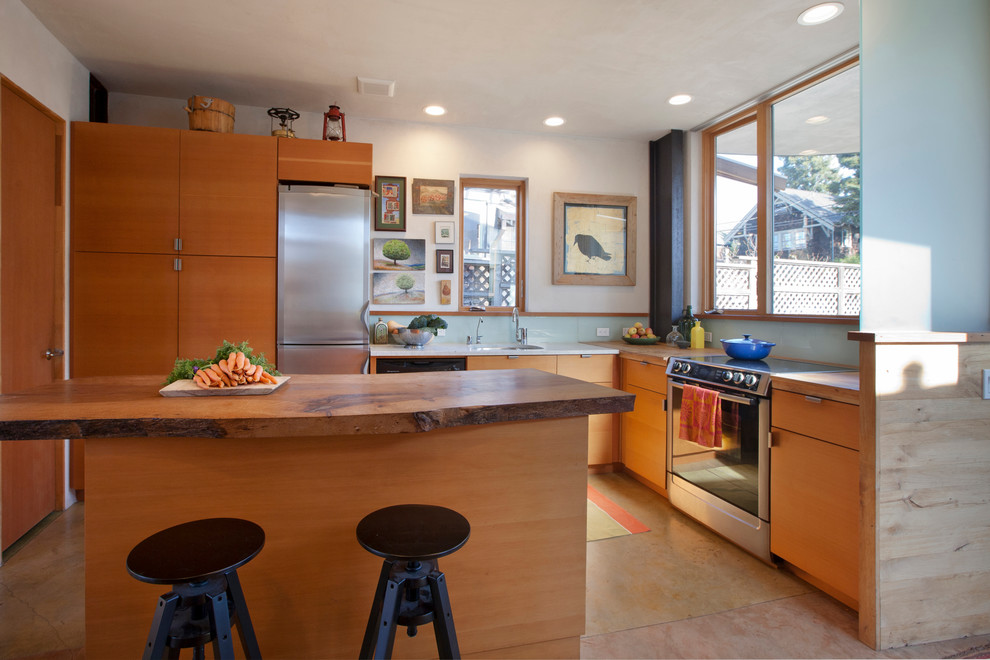 Stilmix Küche in L-Form mit Unterbauwaschbecken, flächenbündigen Schrankfronten, hellbraunen Holzschränken, Arbeitsplatte aus Holz, Küchenrückwand in Blau, Glasrückwand, Küchengeräten aus Edelstahl und Kücheninsel in San Francisco