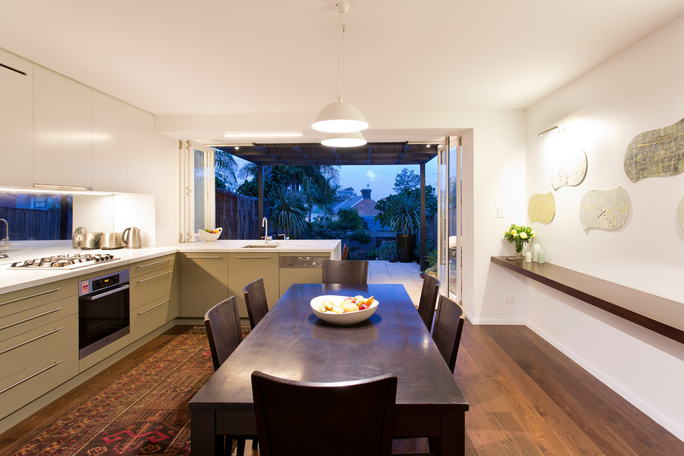 シドニーにあるコンテンポラリースタイルのおしゃれなキッチン (フラットパネル扉のキャビネット、緑のキャビネット、メタリックのキッチンパネル、ガラス板のキッチンパネル、シルバーの調理設備) の写真