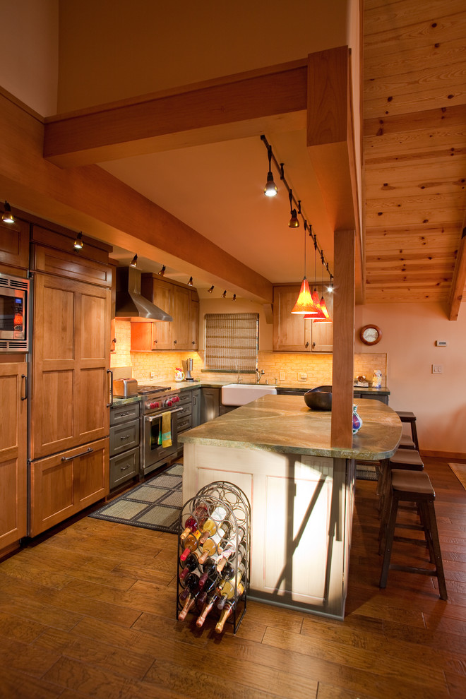 Exempel på ett mellanstort rustikt kök, med en rustik diskho, luckor med infälld panel, skåp i mellenmörkt trä, granitbänkskiva, beige stänkskydd, stänkskydd i tunnelbanekakel, integrerade vitvaror, mellanmörkt trägolv och en köksö