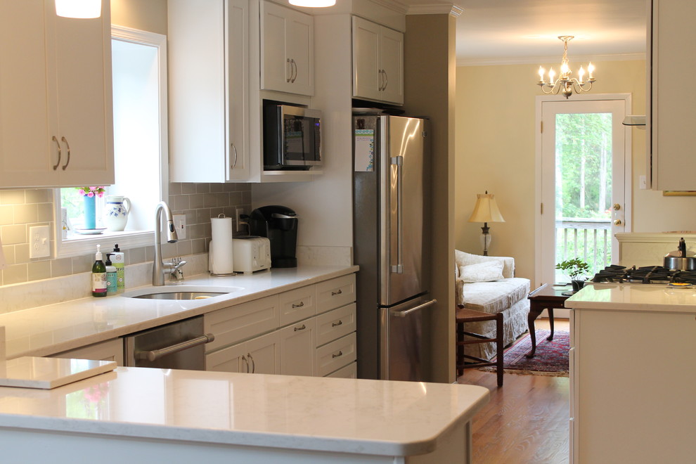 Imagen de cocina comedor moderna de tamaño medio con puertas de armario blancas, salpicadero beige, salpicadero de azulejos de cerámica y electrodomésticos de acero inoxidable