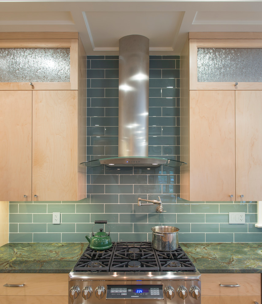 This is an example of a large eclectic u-shaped kitchen in DC Metro with a submerged sink, flat-panel cabinets, medium wood cabinets, granite worktops, green splashback, glass tiled splashback, stainless steel appliances, medium hardwood flooring and an island.