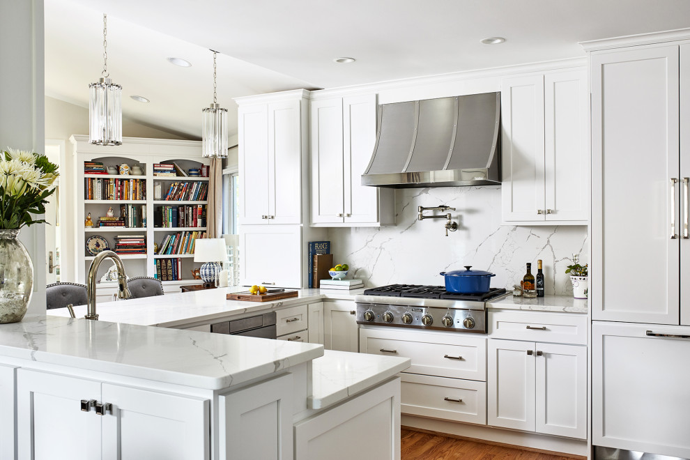Idee per una cucina classica di medie dimensioni con ante bianche, paraspruzzi bianco, elettrodomestici in acciaio inossidabile, pavimento in legno massello medio e top bianco