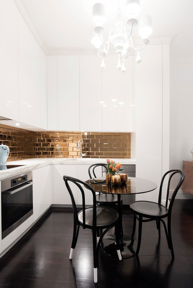 Moderne Wohnküche mit flächenbündigen Schrankfronten, weißen Schränken, Küchenrückwand in Metallic, Rückwand aus Metrofliesen und dunklem Holzboden in Sydney