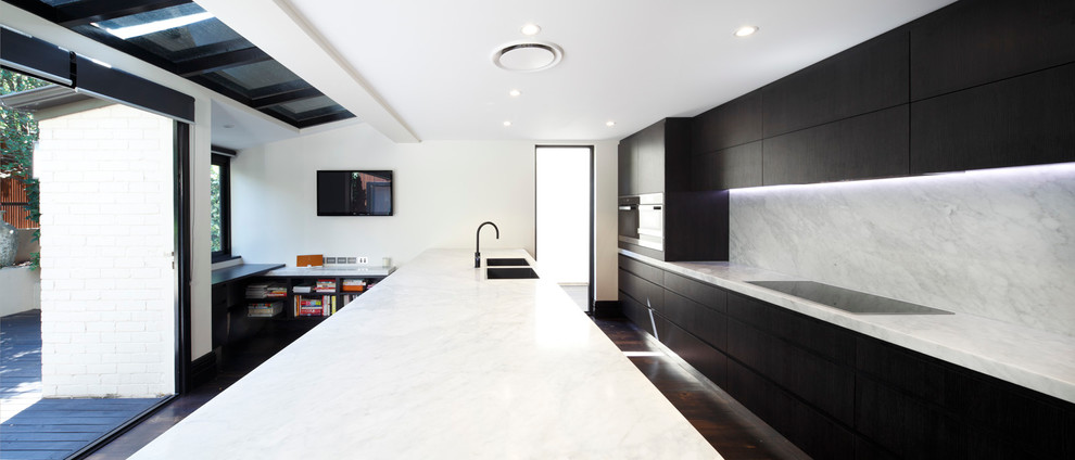 Contemporary single-wall kitchen pantry in Sydney with a double-bowl sink, flat-panel cabinets, dark wood cabinets, marble worktops, stone tiled splashback, stainless steel appliances, dark hardwood flooring and an island.