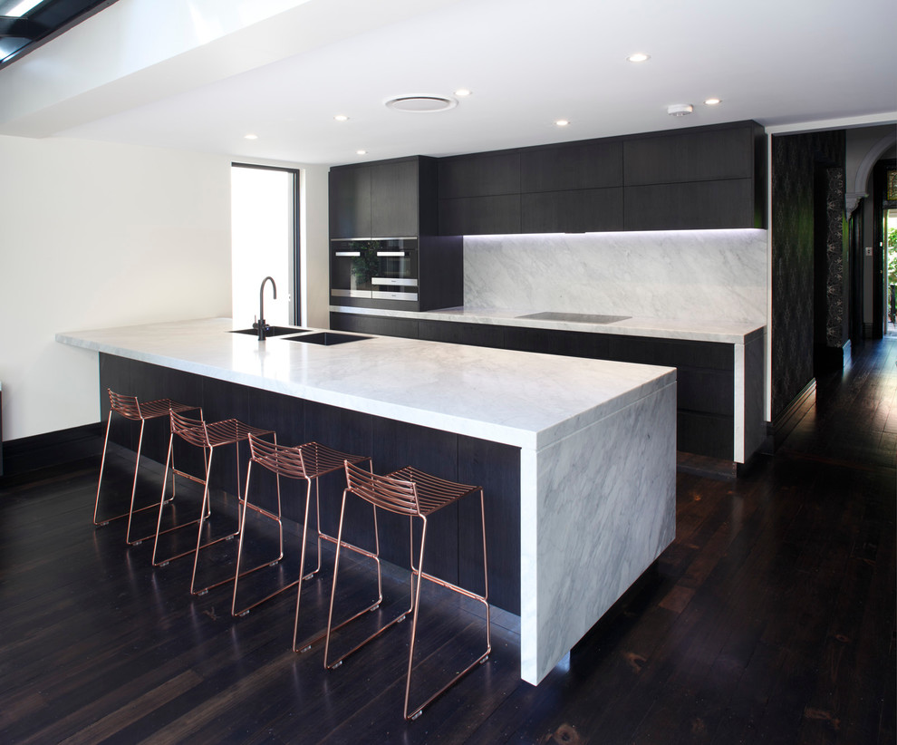 This is an example of a contemporary single-wall kitchen pantry in Sydney with a double-bowl sink, flat-panel cabinets, dark wood cabinets, marble worktops, stone tiled splashback, stainless steel appliances, dark hardwood flooring and an island.