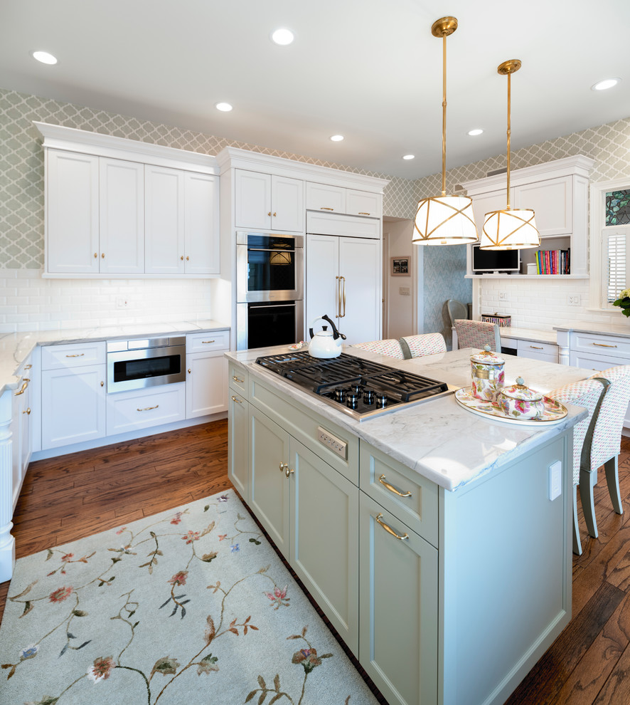 Large transitional u-shaped medium tone wood floor and brown floor enclosed kitchen photo in Cincinnati with an undermount sink, shaker cabinets, white cabinets, white backsplash, subway tile backsplash, paneled appliances, an island, gray countertops and marble countertops