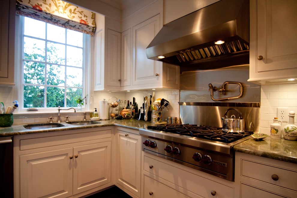 Example of a large classic kitchen design in Atlanta with an undermount sink, white cabinets, granite countertops, white backsplash, ceramic backsplash and stainless steel appliances