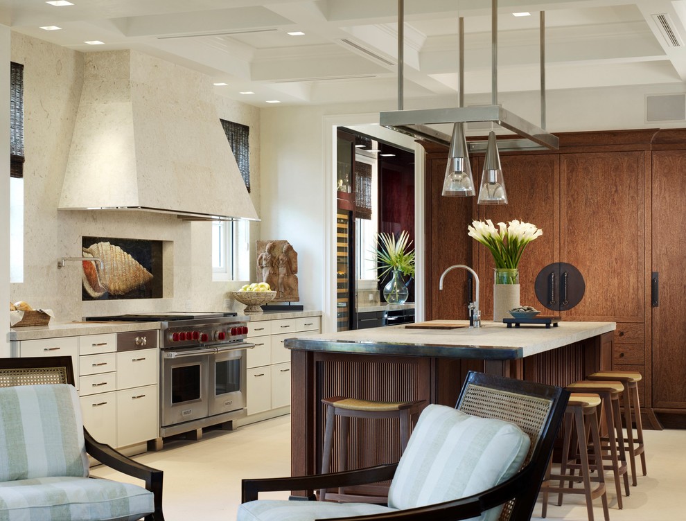 Cette image montre une cuisine américaine traditionnelle avec des portes de placard blanches, un plan de travail en granite, un électroménager en acier inoxydable et îlot.