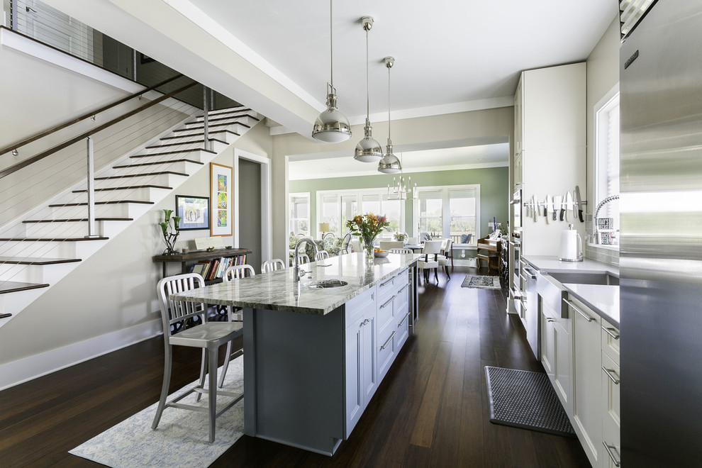 Large transitional galley bamboo floor and brown floor open concept kitchen photo in Charleston with a farmhouse sink, granite countertops, gray backsplash, ceramic backsplash, stainless steel appliances, an island, gray countertops, recessed-panel cabinets and white cabinets