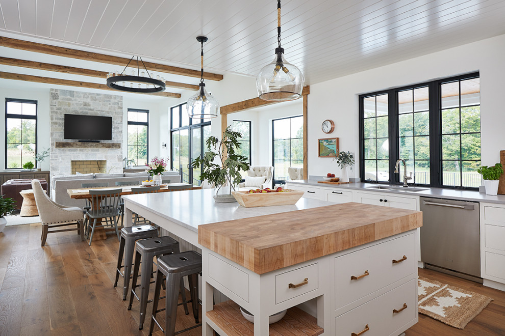 Design ideas for a farmhouse u-shaped open plan kitchen in Grand Rapids with a submerged sink, white cabinets, stainless steel appliances, an island, brown floors, shaker cabinets, medium hardwood flooring, white worktops and a timber clad ceiling.