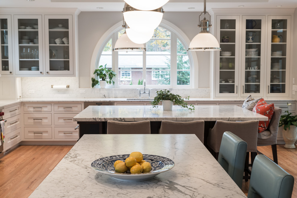 Foto på ett vintage kök, med en undermonterad diskho, vita skåp, marmorbänkskiva, vitt stänkskydd och rostfria vitvaror