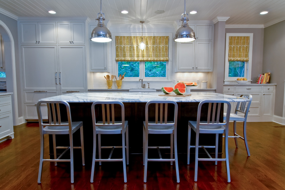 Example of a transitional kitchen design in Minneapolis with a farmhouse sink, shaker cabinets, white cabinets, white backsplash, subway tile backsplash and paneled appliances