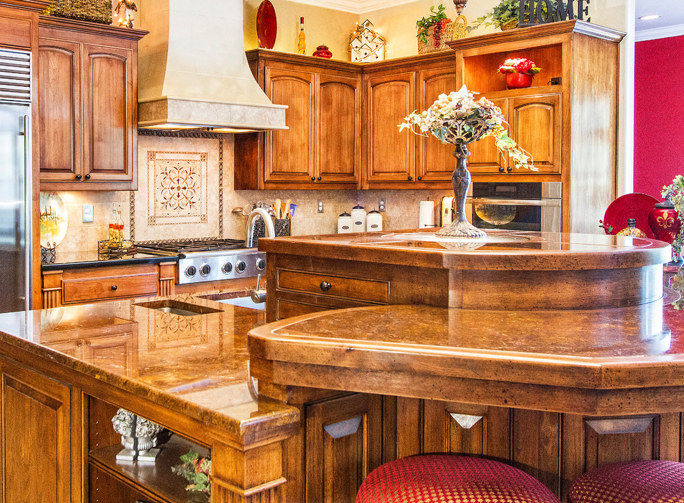 Bild på ett mellanstort vintage kök, med en undermonterad diskho, luckor med upphöjd panel, skåp i mellenmörkt trä, bänkskiva i kvartsit, beige stänkskydd, stänkskydd i keramik, rostfria vitvaror, kalkstensgolv, en köksö och beiget golv
