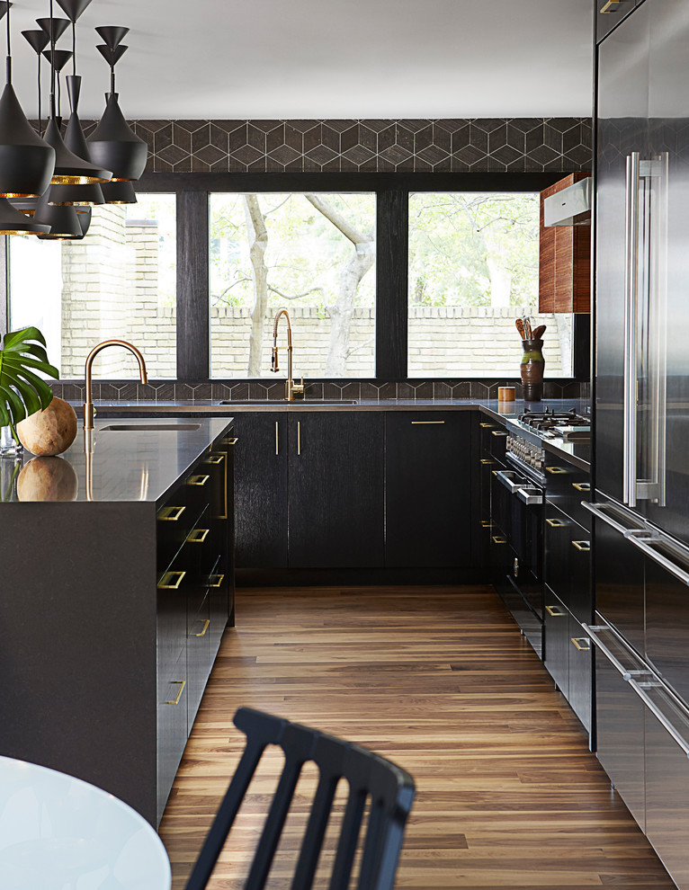 Inspiration for a mid-sized contemporary u-shaped medium tone wood floor and brown floor eat-in kitchen remodel in Dallas with an undermount sink, flat-panel cabinets, dark wood cabinets, solid surface countertops, black backsplash, mosaic tile backsplash, stainless steel appliances and an island
