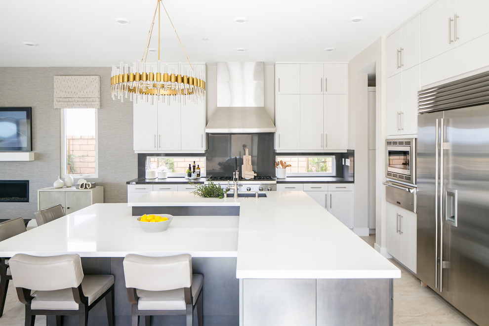 Inspiration for a contemporary l-shaped open plan kitchen in San Diego with white cabinets, quartz worktops, black splashback, stainless steel appliances, an island and white worktops.