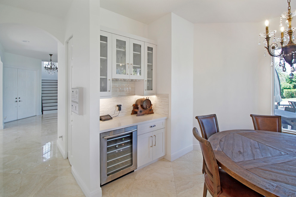 Exempel på ett mycket stort modernt kök, med en undermonterad diskho, skåp i shakerstil, vita skåp, bänkskiva i kvarts, vitt stänkskydd, stänkskydd i stenkakel, rostfria vitvaror, klinkergolv i porslin, en köksö och beiget golv