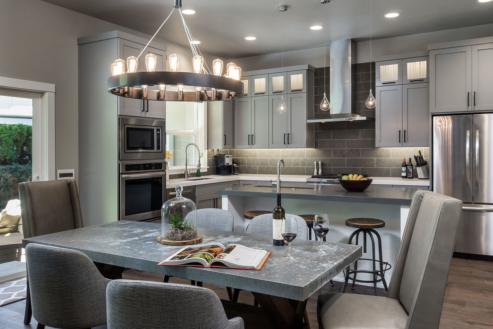 Example of a large transitional l-shaped medium tone wood floor eat-in kitchen design in Portland with an undermount sink, shaker cabinets, gray cabinets, quartz countertops, gray backsplash, porcelain backsplash, stainless steel appliances and an island