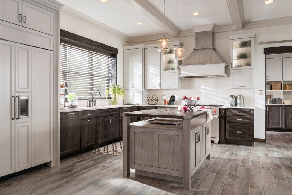 Inspiration for a large traditional l-shaped kitchen/diner in Minneapolis with recessed-panel cabinets, white cabinets, white splashback, ceramic splashback, integrated appliances, porcelain flooring, an island, grey floors, marble worktops and white worktops.