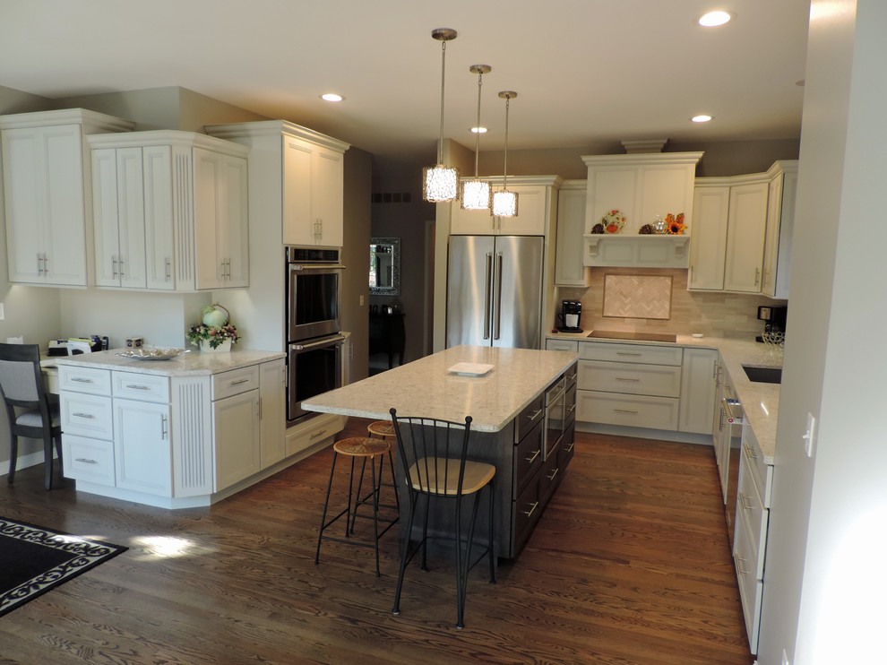 Example of a mid-sized classic medium tone wood floor and brown floor eat-in kitchen design in Phoenix with a single-bowl sink, recessed-panel cabinets, white cabinets, quartz countertops, gray backsplash, limestone backsplash and stainless steel appliances