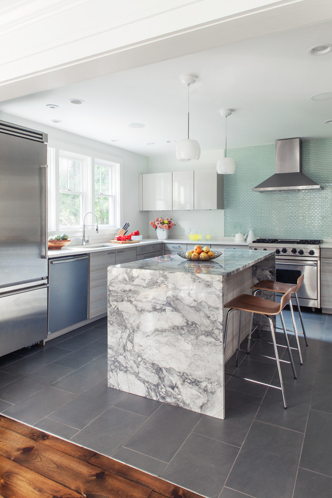 Modelo de cocinas en L contemporánea con fregadero bajoencimera, armarios con paneles lisos, salpicadero gris y electrodomésticos de acero inoxidable
