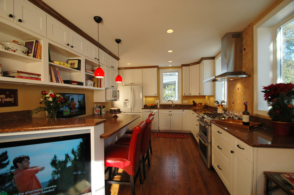 Enclosed kitchen - traditional galley enclosed kitchen idea in DC Metro with an undermount sink, shaker cabinets, yellow cabinets, granite countertops, black backsplash, subway tile backsplash and white appliances
