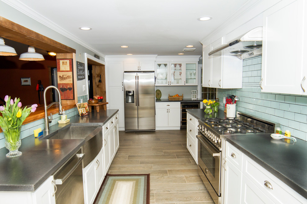 Bild på ett mellanstort vintage kök, med en rustik diskho, skåp i shakerstil, vita skåp, bänkskiva i betong, blått stänkskydd, stänkskydd i glaskakel, rostfria vitvaror och klinkergolv i porslin