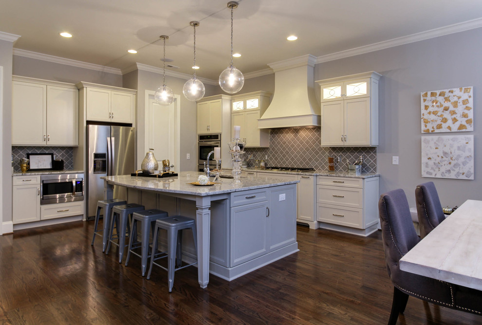 Inspiration for a mid-sized transitional l-shaped medium tone wood floor open concept kitchen remodel in Raleigh with a single-bowl sink, recessed-panel cabinets, gray cabinets, granite countertops, gray backsplash, ceramic backsplash, stainless steel appliances and an island