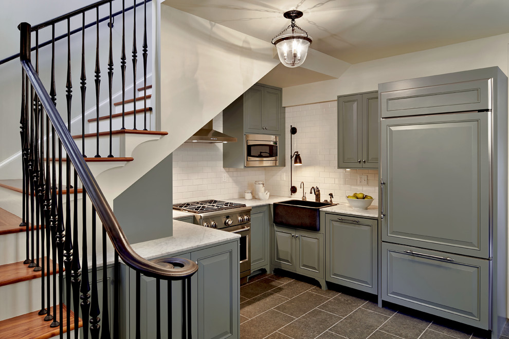 Photo of a traditional u-shaped kitchen in Seattle with a belfast sink, raised-panel cabinets, blue cabinets, white splashback, metro tiled splashback, integrated appliances and marble worktops.