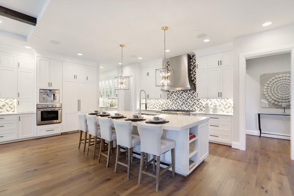 Example of a large trendy l-shaped medium tone wood floor and brown floor open concept kitchen design in Seattle with an island, an undermount sink, recessed-panel cabinets, white cabinets, quartzite countertops, multicolored backsplash, paneled appliances and white countertops