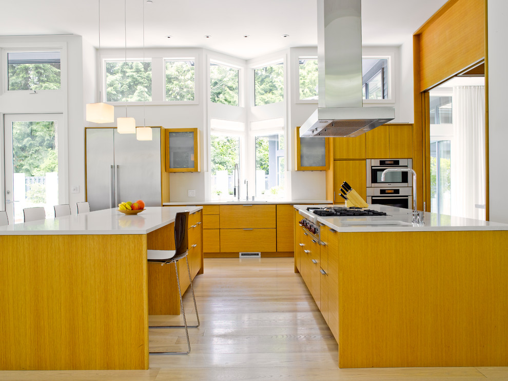 Example of a trendy single-wall light wood floor open concept kitchen design in Seattle with two islands, flat-panel cabinets, medium tone wood cabinets, an undermount sink and stainless steel appliances