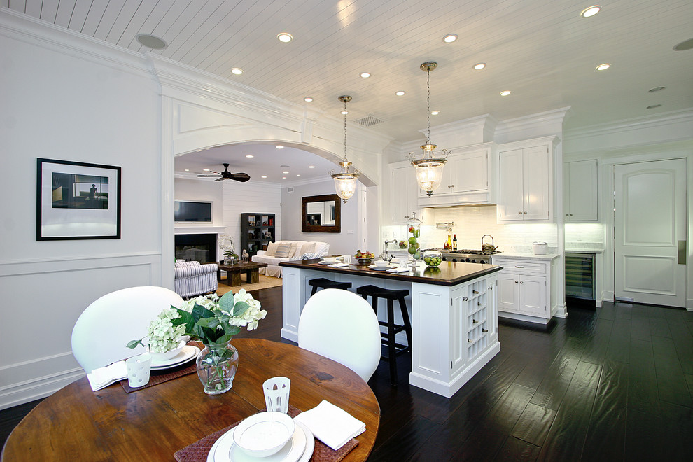 Ejemplo de cocina clásica con armarios con paneles empotrados, puertas de armario blancas, salpicadero blanco y electrodomésticos de acero inoxidable