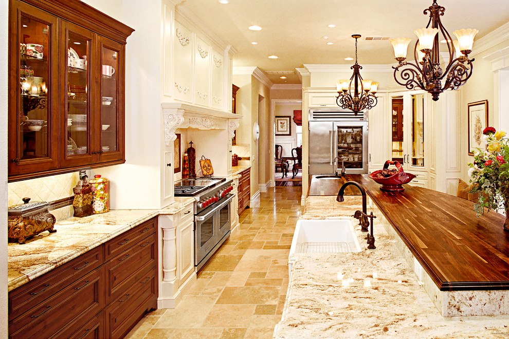 Large tuscan galley limestone floor and beige floor open concept kitchen photo in Orange County with a farmhouse sink, granite countertops, ceramic backsplash, stainless steel appliances, raised-panel cabinets, distressed cabinets, beige backsplash, an island and beige countertops
