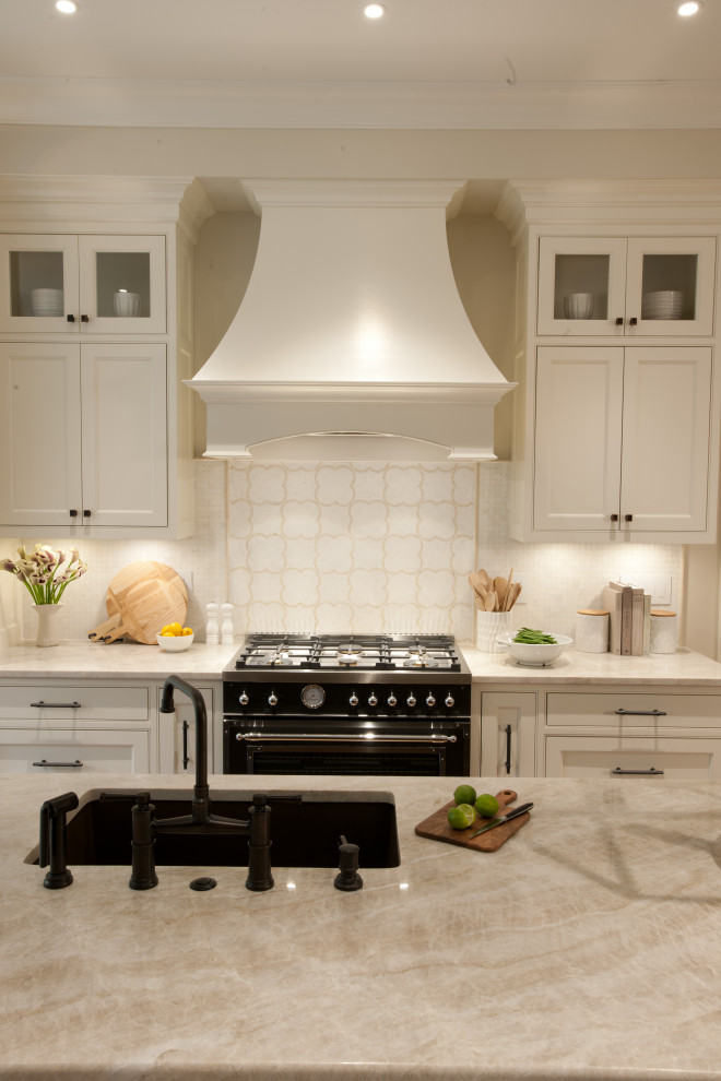 Idéer för mellanstora vintage flerfärgat kök, med en integrerad diskho, luckor med infälld panel, vita skåp, marmorbänkskiva, flerfärgad stänkskydd, stänkskydd i marmor, integrerade vitvaror, mellanmörkt trägolv, en köksö och brunt golv