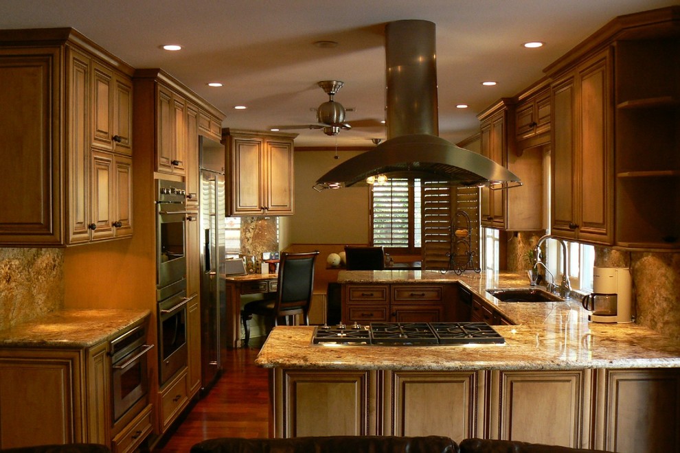 Exempel på ett mellanstort medelhavsstil kök, med luckor med upphöjd panel, skåp i mellenmörkt trä, granitbänkskiva, flerfärgad stänkskydd, stänkskydd i sten, rostfria vitvaror, mellanmörkt trägolv, en halv köksö, en enkel diskho och brunt golv