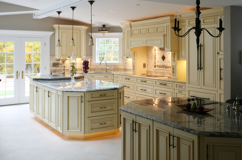 Inspiration for a large mediterranean l-shaped limestone floor and beige floor open concept kitchen remodel in Portland Maine with an undermount sink, shaker cabinets, beige cabinets, granite countertops, beige backsplash, ceramic backsplash, colored appliances and an island