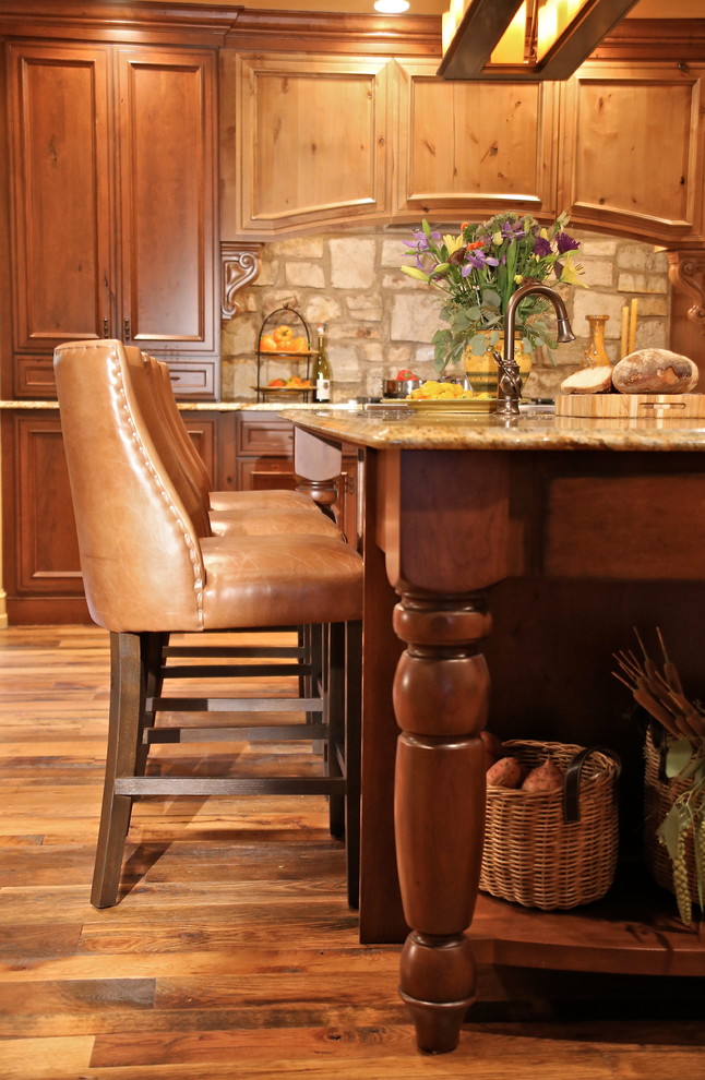 Foto på ett stort medelhavsstil kök, med luckor med upphöjd panel, skåp i mörkt trä, granitbänkskiva, brunt stänkskydd, stänkskydd i stenkakel, rostfria vitvaror, mörkt trägolv, en köksö och brunt golv