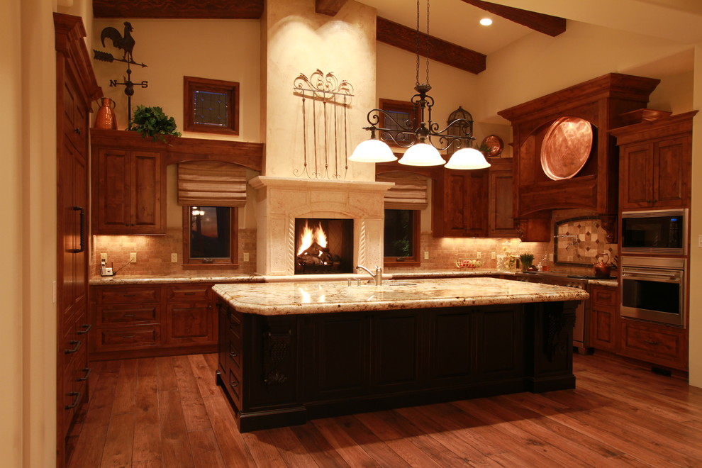 Exempel på ett stort medelhavsstil kök, med en dubbel diskho, skåp i mörkt trä, granitbänkskiva, rostfria vitvaror och mellanmörkt trägolv