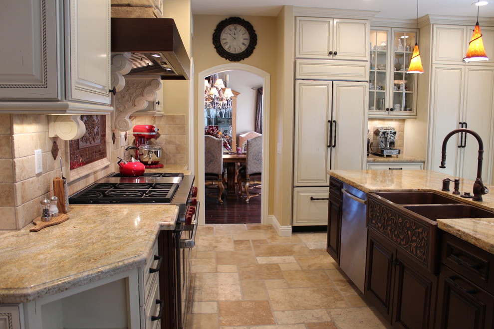 Exempel på ett stort medelhavsstil kök, med en köksö, luckor med upphöjd panel, vita skåp, granitbänkskiva, beige stänkskydd, stänkskydd i stenkakel, integrerade vitvaror, en rustik diskho och travertin golv