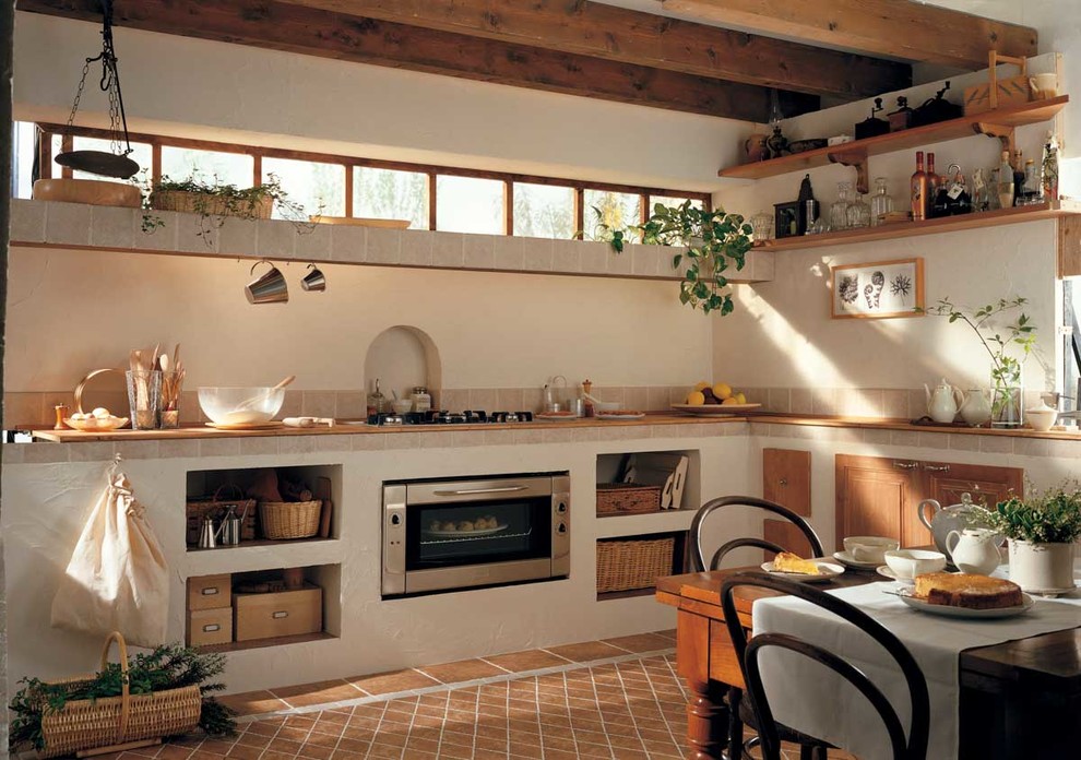 Immagine di una cucina abitabile mediterranea con nessun'anta e nessuna isola