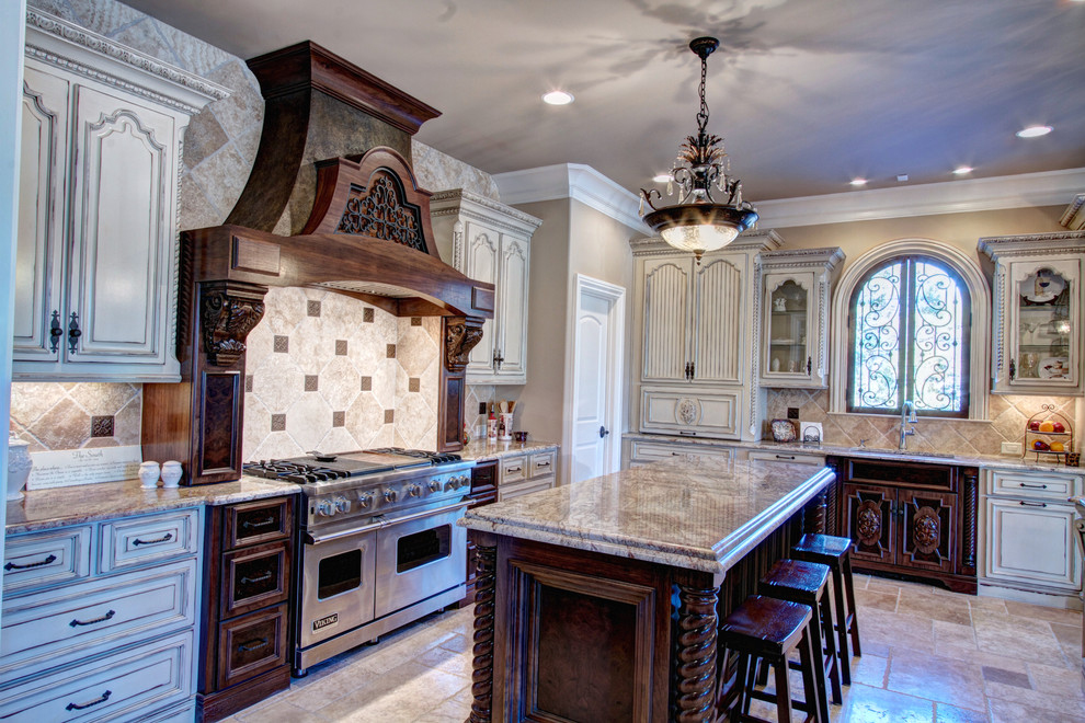 Example of a large tuscan l-shaped travertine floor open concept kitchen design in Atlanta with an undermount sink, raised-panel cabinets, dark wood cabinets, granite countertops, beige backsplash, stone tile backsplash, stainless steel appliances and two islands