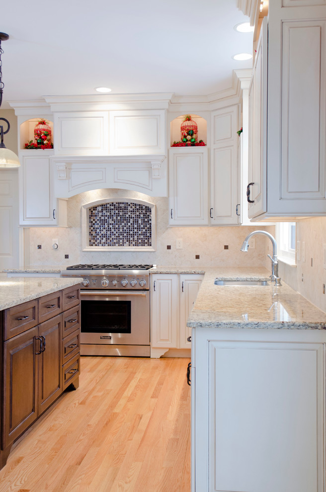 Foto de cocina mediterránea con puertas de armario blancas, encimera de granito, salpicadero beige, salpicadero de azulejos tipo metro y electrodomésticos de acero inoxidable