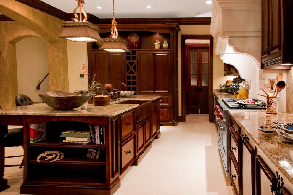 This is an example of a mediterranean kitchen in Miami with a belfast sink, raised-panel cabinets, dark wood cabinets and integrated appliances.