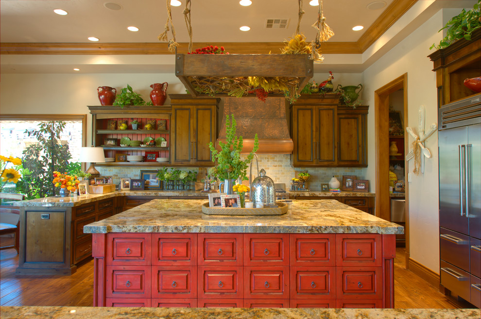 ラスベガスにある地中海スタイルのおしゃれなキッチン (御影石カウンター、赤いキャビネット) の写真