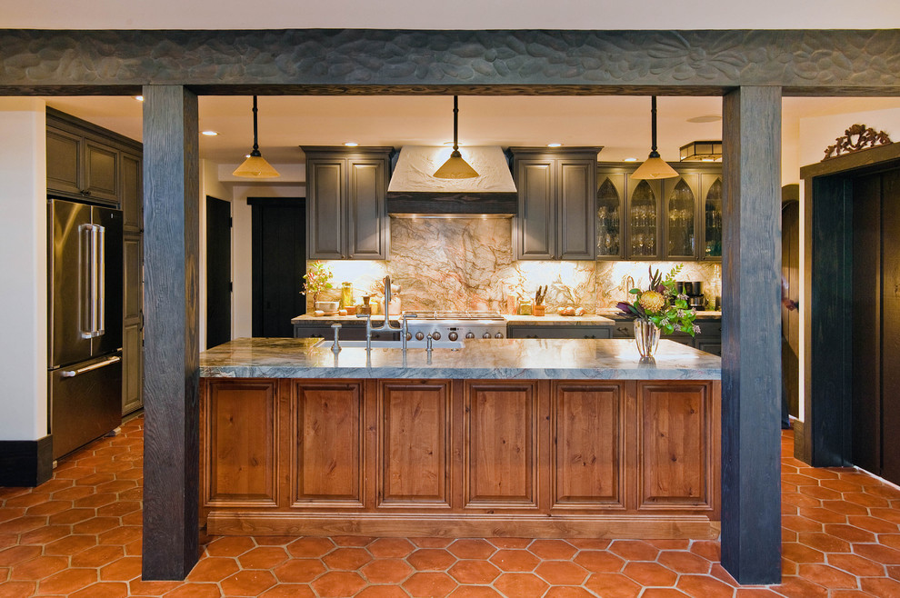 Foto på ett medelhavsstil kök, med luckor med upphöjd panel, grå skåp, rostfria vitvaror och stänkskydd i sten