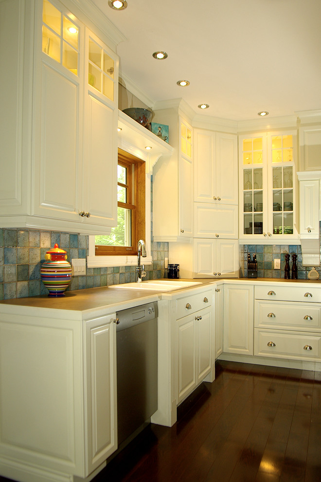 Foto på ett stort vintage kök, med rostfria vitvaror, en köksö, en nedsänkt diskho, luckor med upphöjd panel, vita skåp, laminatbänkskiva, blått stänkskydd, stänkskydd i keramik och mörkt trägolv