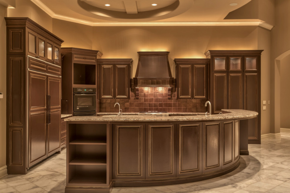 Photo of an expansive mediterranean l-shaped open plan kitchen in Omaha with a submerged sink, recessed-panel cabinets, dark wood cabinets, granite worktops, black appliances, marble flooring and multiple islands.